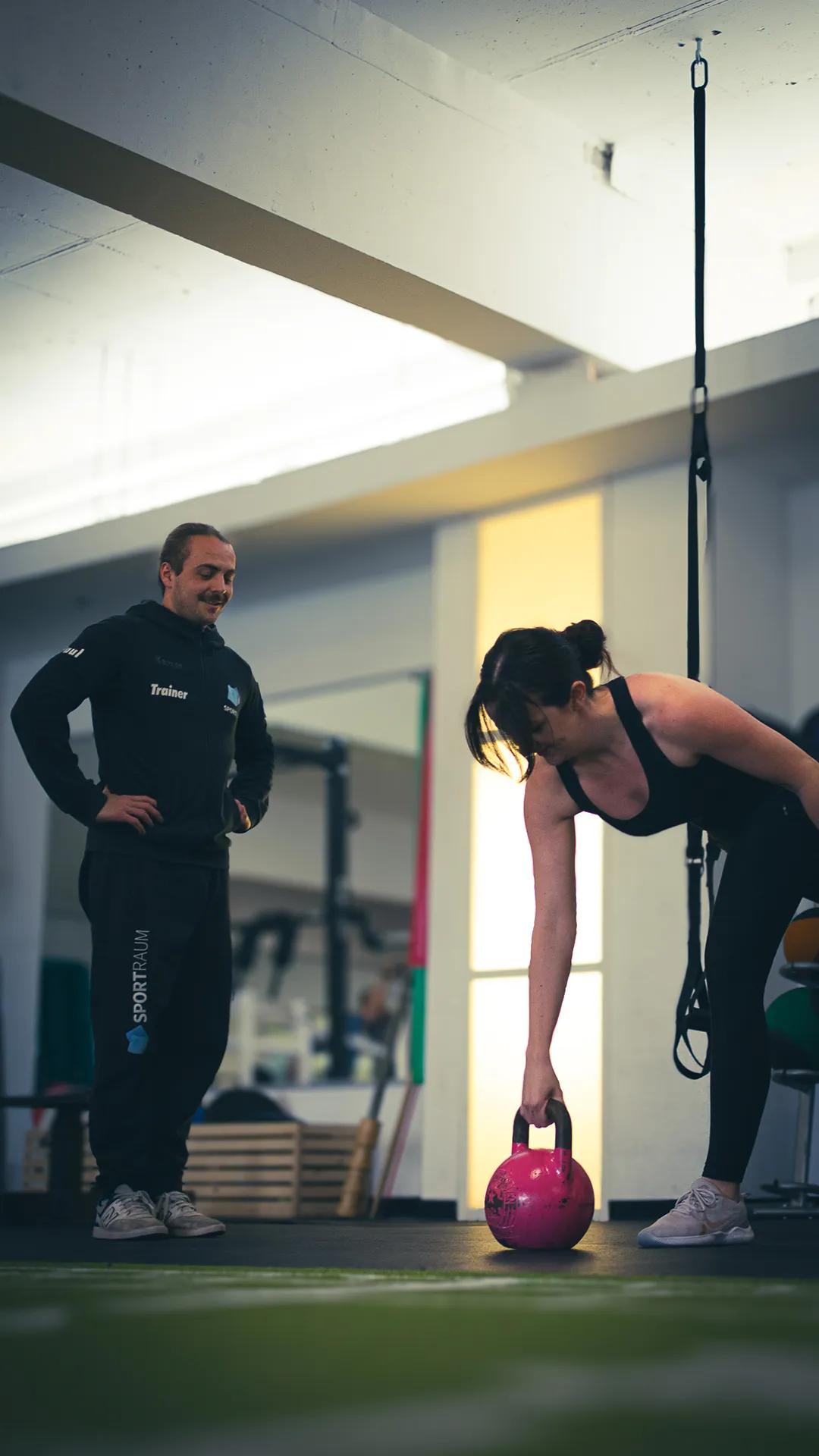 Sportraum Mainz Trainer hilft bei einer Fitnessübung