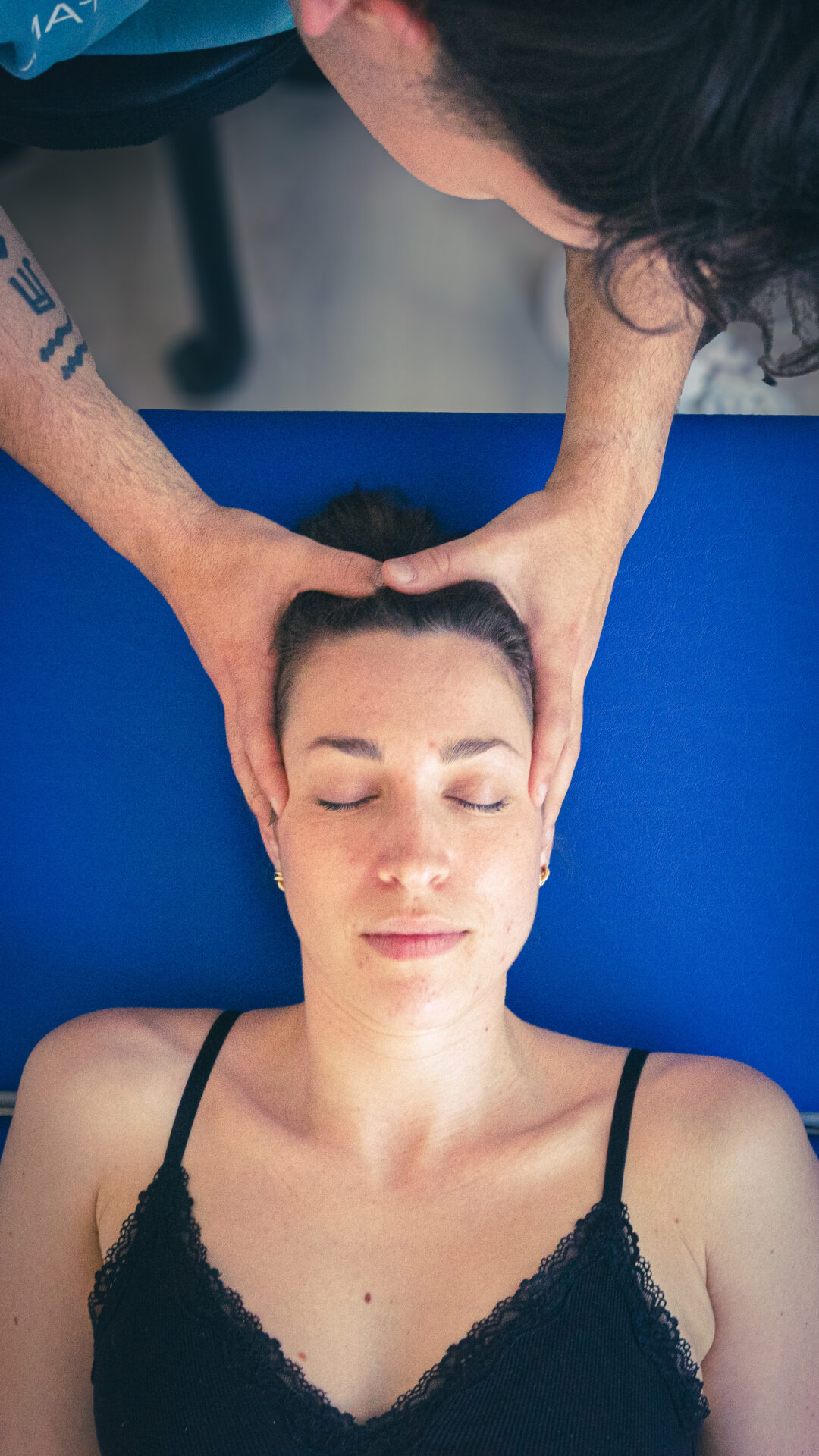 Patientin liegt auf Behandlungsliege während einer Kopfbehandlung